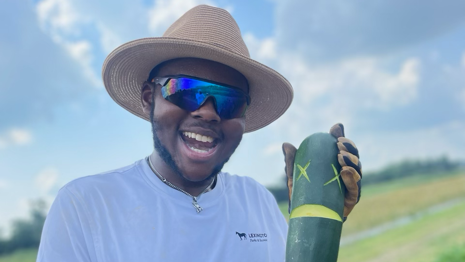 Farmer Clark makes a face out of a split zucchini