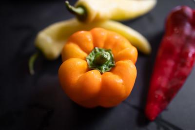 A bell pepper and other peppers on a table
